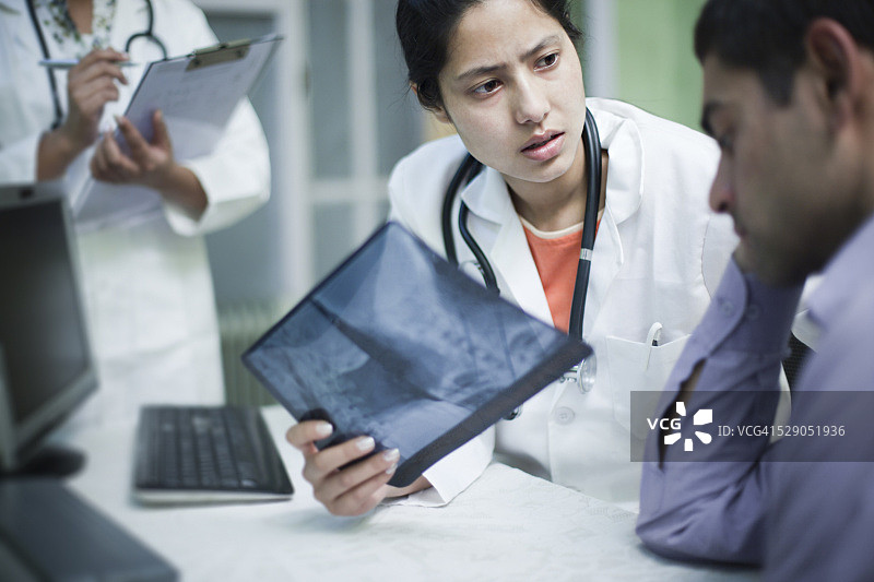 女骨科医生拿着X光片安慰病人图片素材