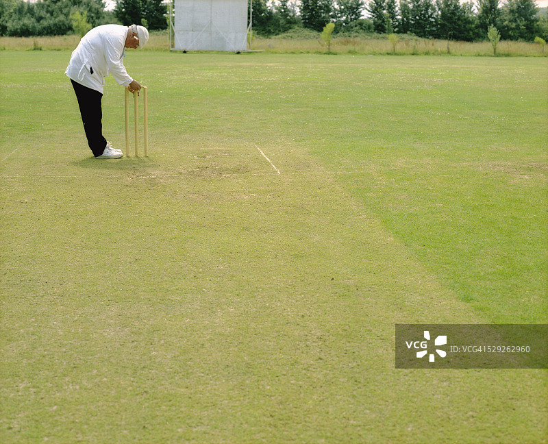 男人调整板球场上的门柱图片素材