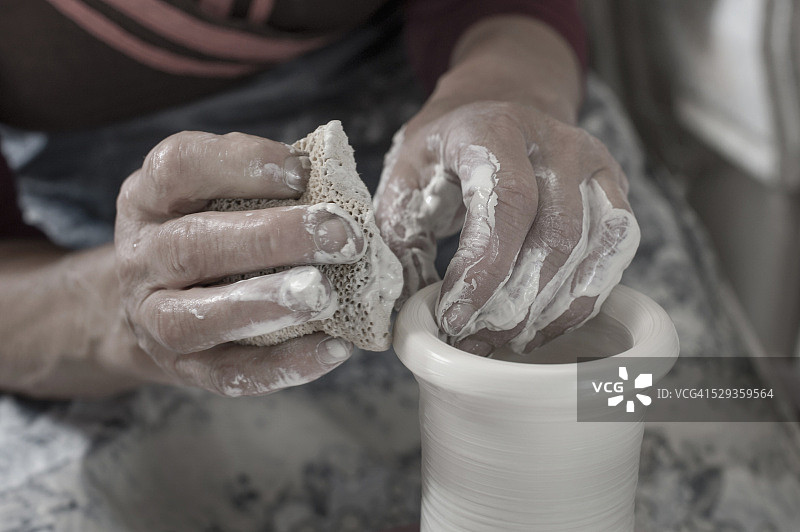 在德国巴伐利亚，女陶艺家用海绵塑造粘土特写图片素材