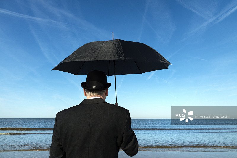 站在海滩上眺望大海的英国男人图片素材