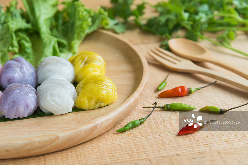 木质背景上的蒸米皮饺子图片素材