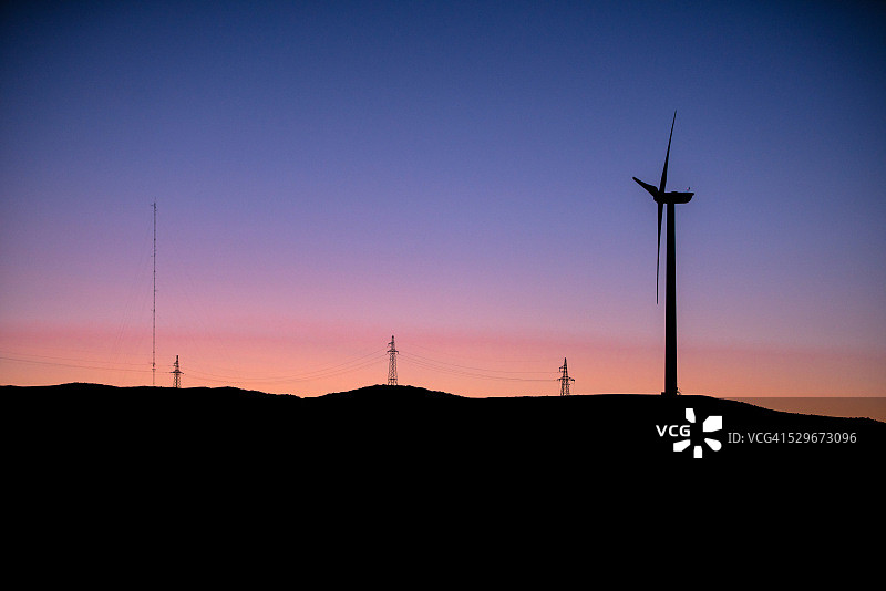 红橙日落下的风力发电机图片素材