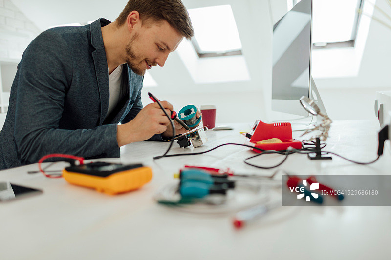 男人在办公室焊接电路板图片素材