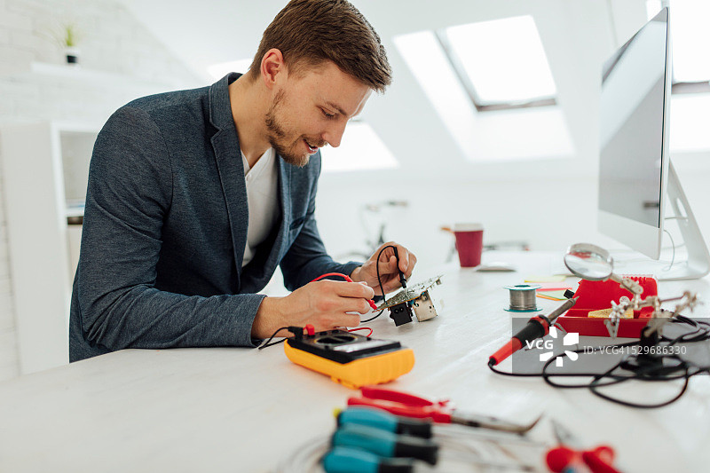 男人在办公室测试电路板图片素材