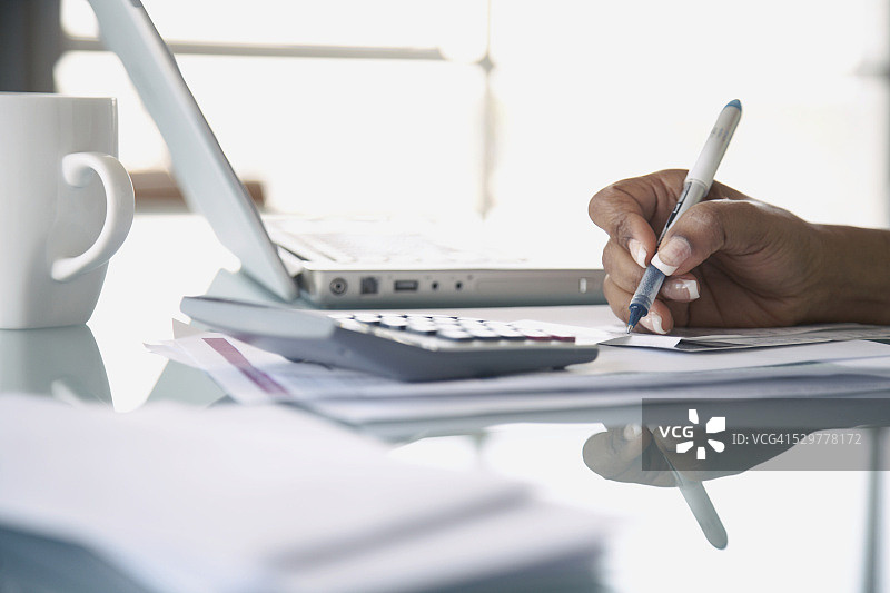女人使用电脑和计算器进行银行业务图片素材