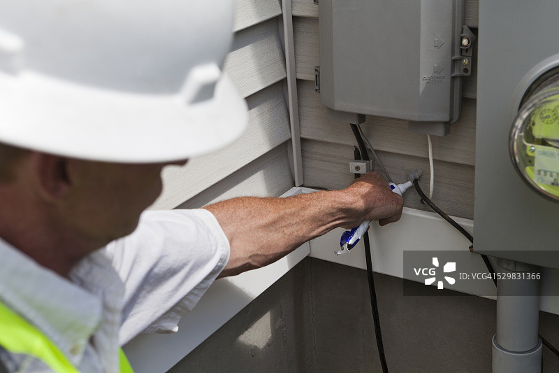 线缆安装工涂抹密封胶图片素材