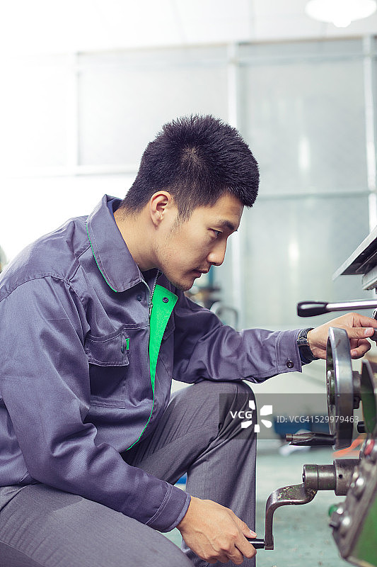 修理工在工厂里忙碌地修理机器图片素材