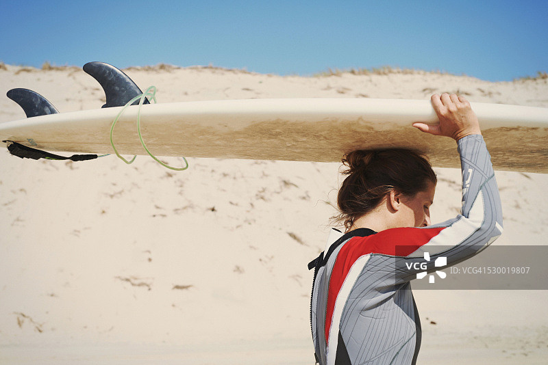 法国拉卡诺海滩上头顶冲浪板的冲浪者图片素材