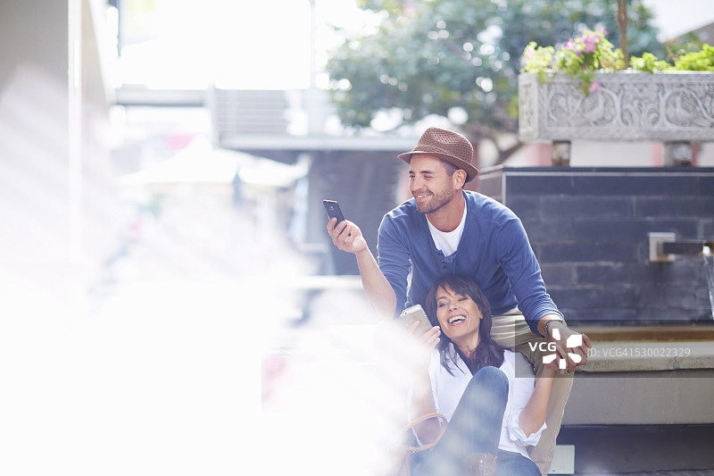 中年夫妇在户外一起看智能手机图片素材