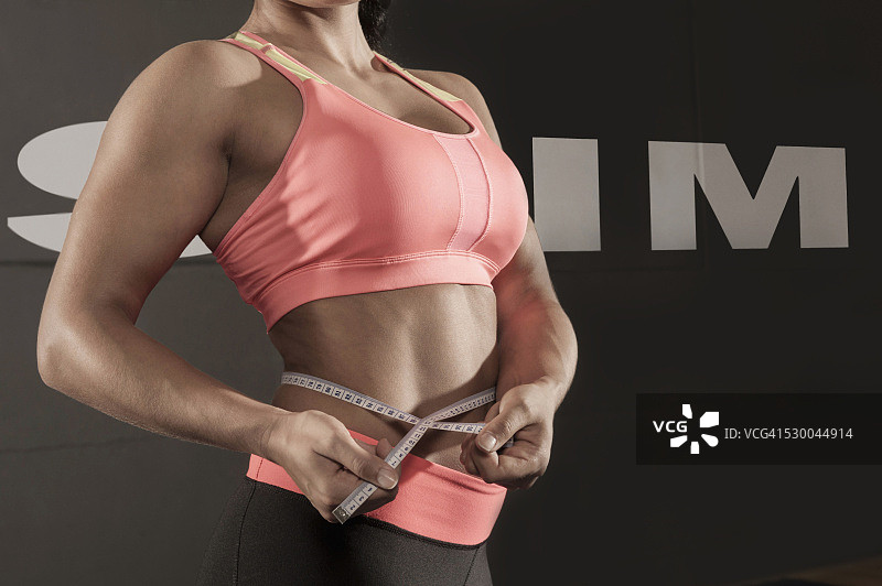 测量腰围的健壮女人特写图片素材