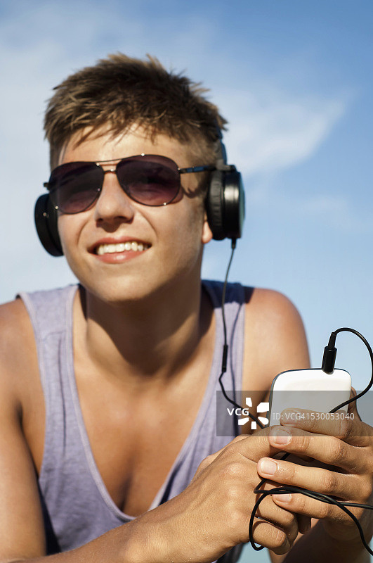 在泰国丽贝岛海滩听音乐的少年肖像图片素材