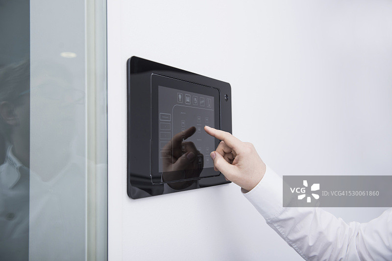 男子在墙上操作控制面板，德国巴伐利亚慕尼黑图片素材