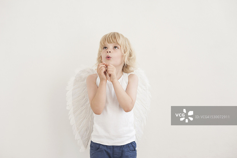 长着天使翅膀向上看的小男孩肖像图片素材