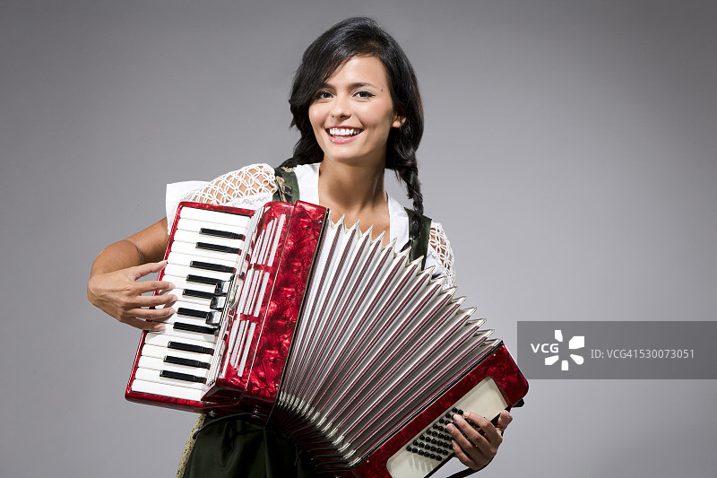演奏手风琴的微笑年轻女人肖像图片素材
