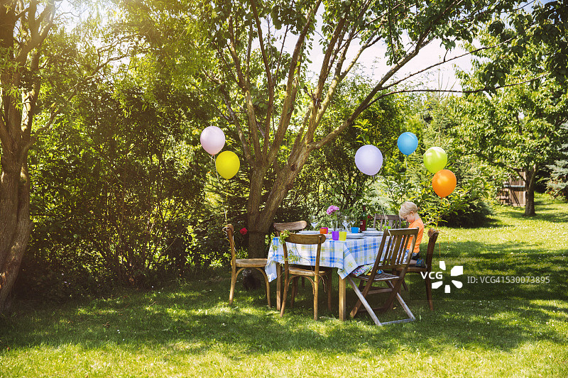 花园里有小男孩的派对餐桌图片素材
