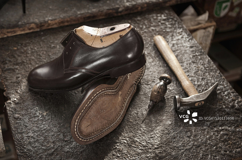 修鞋店里的皮鞋、锥子和锤子图片素材