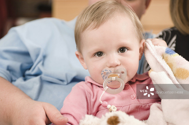 父亲抱着含着奶嘴的女婴的肖像图片素材