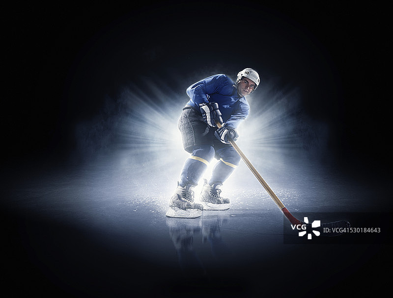 聚光灯下的冰球运动员图片素材