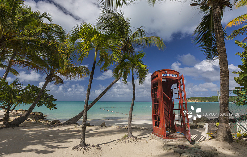 在迪克森湾的椰子树下，废弃的红色电话亭图片素材