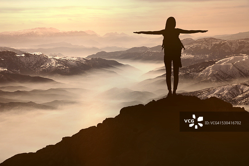 山丘日落时分的女人剪影图片素材