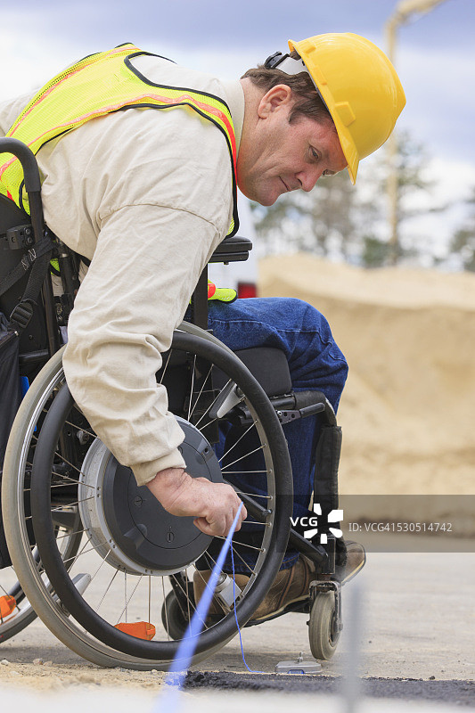 脊髓损伤的施工主管在路面边缘拉粉线图片素材