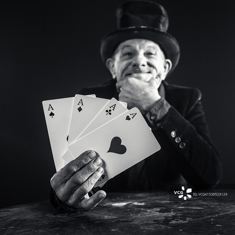 年长的男人用扑克牌变戏法图片素材