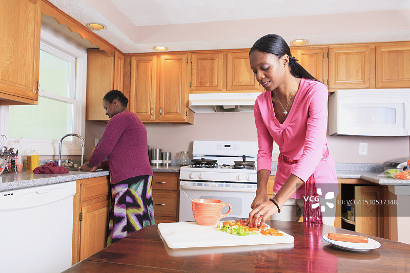 两姐妹在厨房工作，一人有学习障碍图片素材