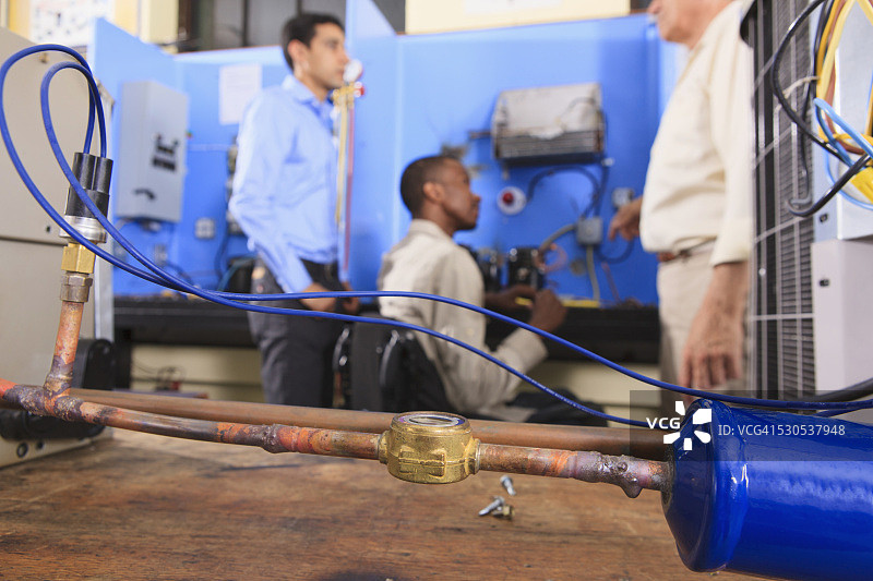 教练与轮椅学生讨论冷凝器盘管和空调传感器图片素材