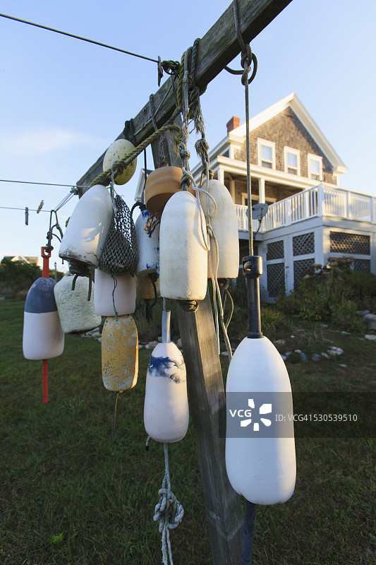 美国罗德岛州布洛克岛度假屋前的晒衣绳柱子上的浮标图片素材