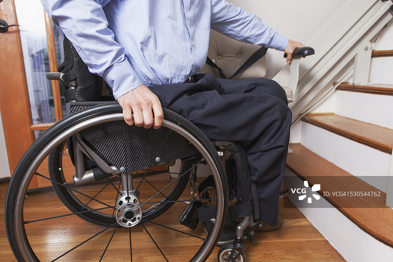 脊髓损伤男子乘坐电动楼梯升降机图片素材