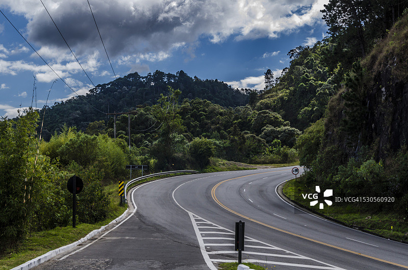 山间树木之间的弓形路图片素材