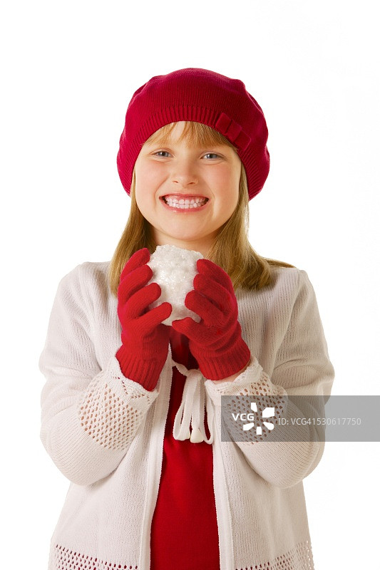 戴红帽子和手套的女孩拿着雪球图片素材