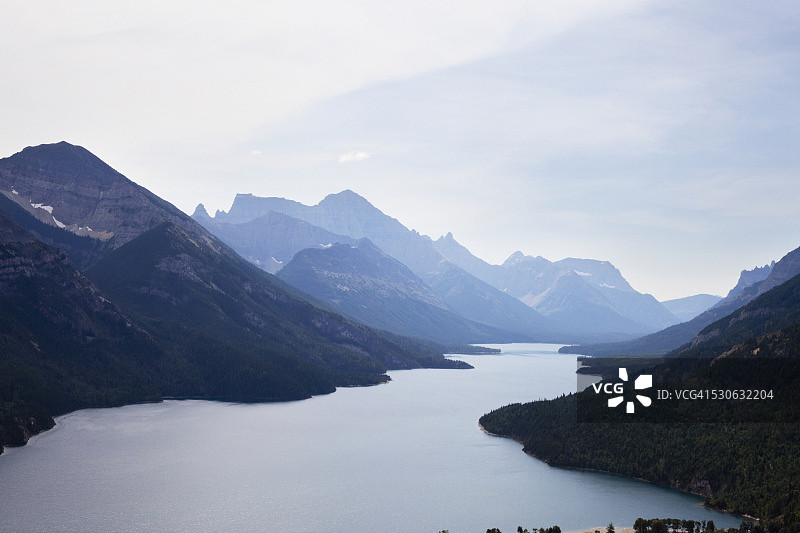 加拿大落基山脉与沃特顿湖的蓝色湖水交汇，加拿大阿尔伯塔省图片素材