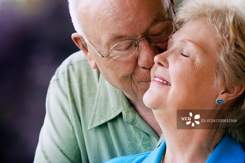 亲吻妻子脸颊的年长男人图片素材