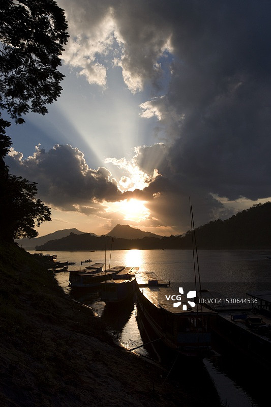 老挝琅勃拉邦湄公河日落时分的船只图片素材