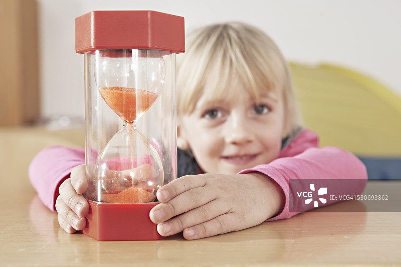 在幼儿园看沙漏的小女孩，德国巴伐利亚州图片素材