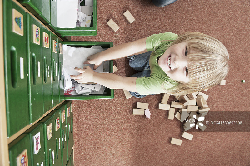 在德国巴伐利亚州幼儿园柜子上玩耍的小男孩图片素材