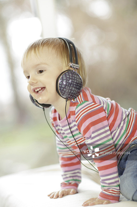 戴着耳机听音乐的幼儿男孩，克罗地亚奥西耶克，欧洲图片素材