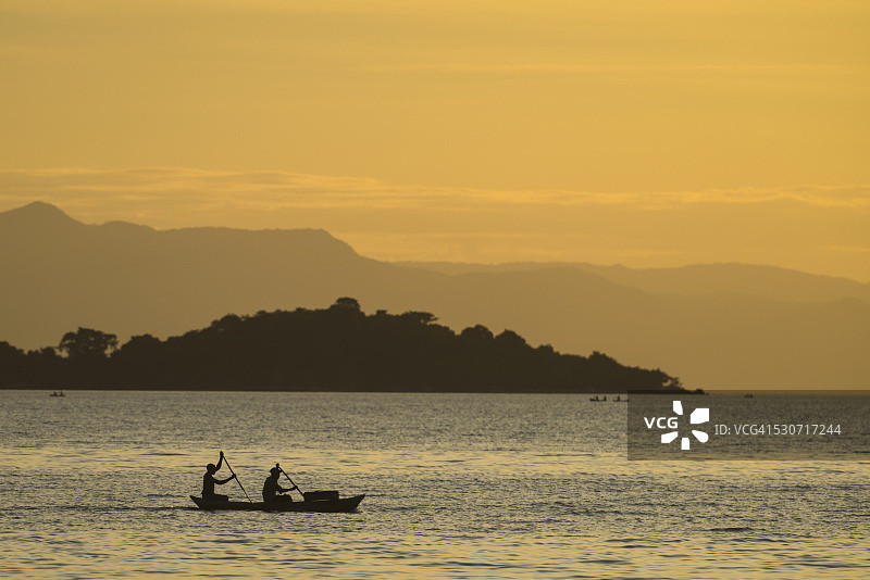 马拉维湖，傍晚离开麦克利尔角的独木舟上的渔民剪影；马拉维图片素材
