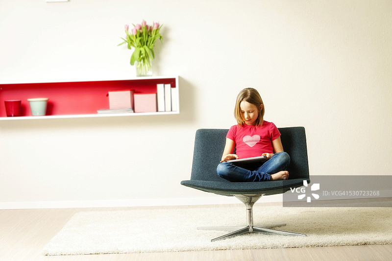 女孩在德国巴伐利亚慕尼黑使用平板电脑坐在椅子上图片素材