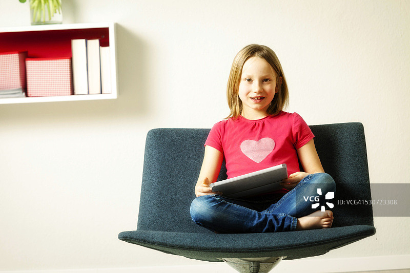 女孩在德国巴伐利亚慕尼黑使用平板电脑坐在椅子上图片素材