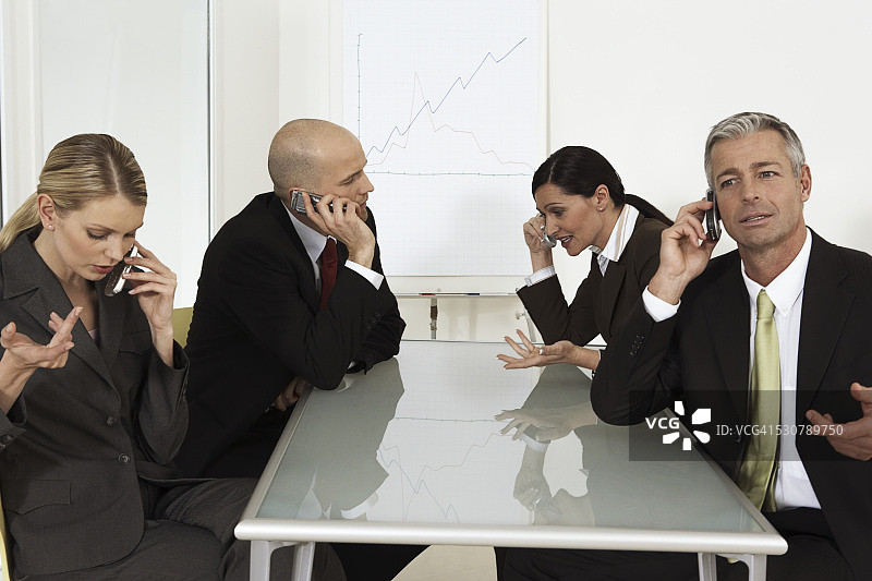 商务人士在会议期间用手机交谈图片素材