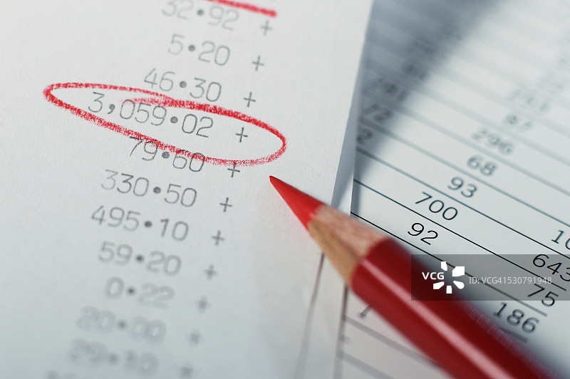 红色铅笔圈出加法机纸带上的数字图片素材