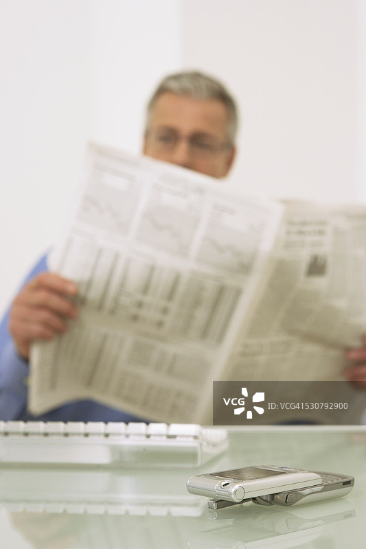 商人在办公桌前读报图片素材