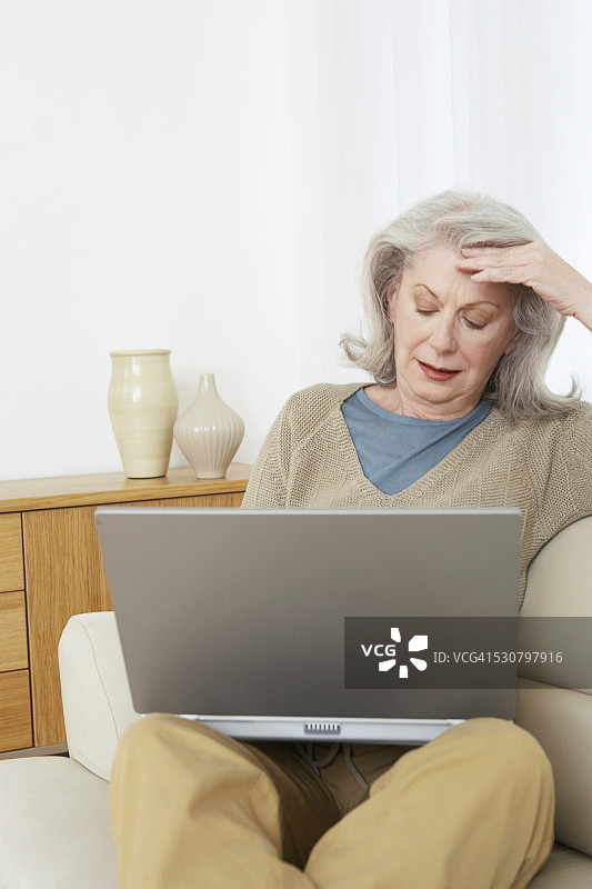 对新笔记本电脑感到沮丧的老年妇女图片素材
