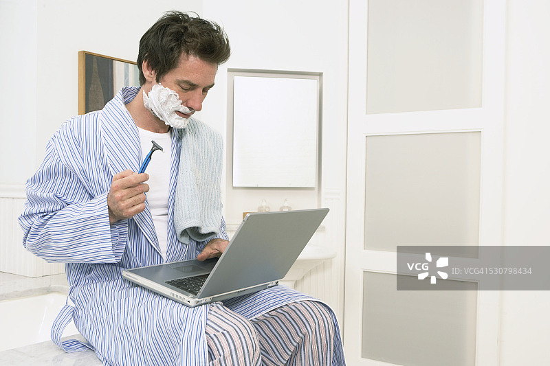 男人同时刮胡子和冲浪图片素材