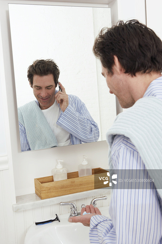 刮胡子时用手机交谈的男人图片素材