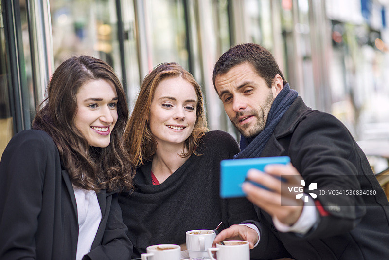 年轻人在巴黎咖啡馆自拍图片素材