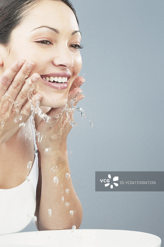 女子往脸上泼水图片素材