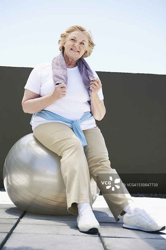 年长的女人在健身球上。图片素材